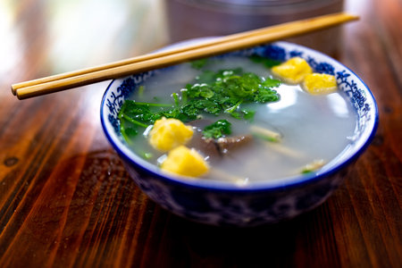 Traditional Chinese rice gruel soup with dumplings and parsleyの写真素材