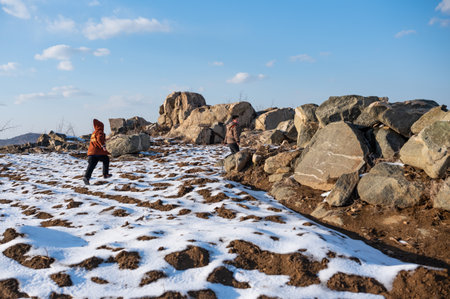 Hiking in the mountains in winter. A woman walks along a snowy path.の写真素材