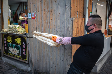 A man in a black protective mask and gloves holds a rope in his hand.