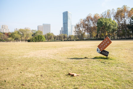 Park sign on grass with cityscape in background, Beijing, Chinaの写真素材