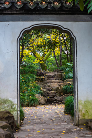 Stone stairs in the garden with yellow leaves and green trees in the backgroundの写真素材