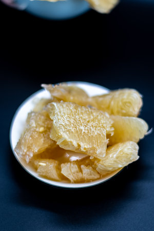 Grapefruit jam in a bowl on a black background. Selective focus.の写真素材