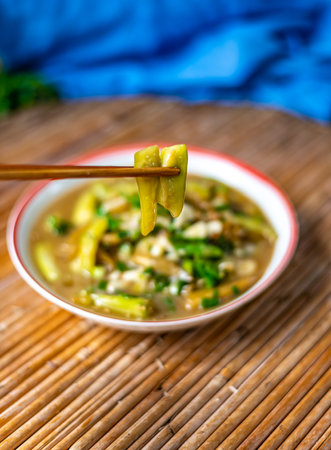 chinese noodle soup with chopsticks on a wooden table.の写真素材