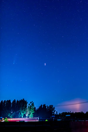 Night sky with stars and a train on the background. Long exposure.