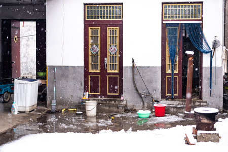 Old house in the snow on the streetの写真素材