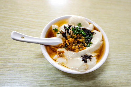 Dumplings in sweet and sour sauce in a bowl on the tableの写真素材