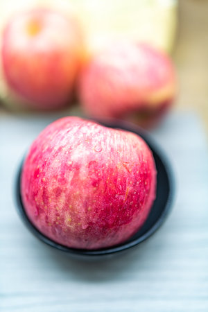 Red apple in bowl on wooden table - Healthy food and drink conceptの写真素材