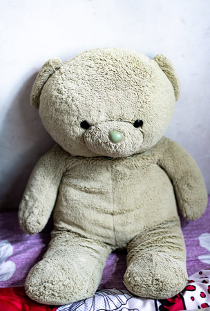 Teddy bear sitting on the bed in the bedroom, soft focusの写真素材