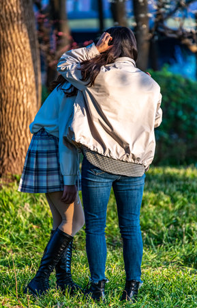 Back view of a young couple embracing each other in the park.の写真素材