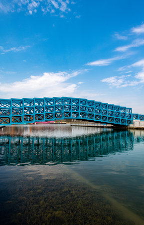 blue steel bridge over the river with blue sky and white clouds backgroundの写真素材