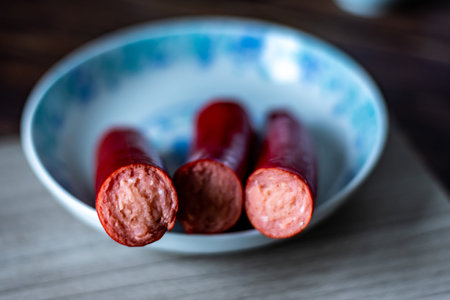 Sausages in a bowl on a wooden table. Selective focus.