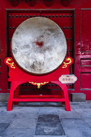 Traditional Chinese percussion instrument on the red wooden door in the temple.の写真素材