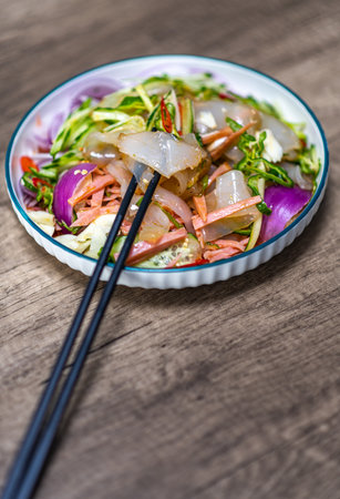 Salad with shrimps and vegetables in bowl on wooden tableの写真素材