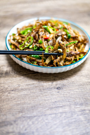 Rice noodles with beef and vegetables in a bowl on wooden backgroundの写真素材