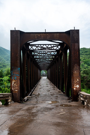 Old rusty iron bridge in the countryside of Thailand. This bridge was built in the 18th century.の写真素材