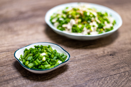 Chopped green onions in a bowl on a wooden background. Selective focus.の写真素材