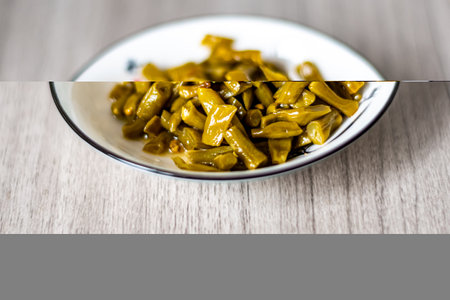 Close up of pickled green beans in a bowl on wooden tableの写真素材