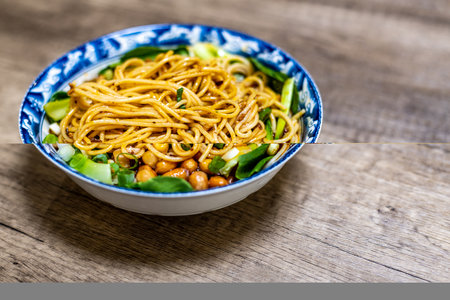 chinese noodle in a bowl on wooden table, food closeupの写真素材