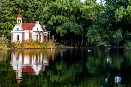 Beautiful summer landscape with lake and old house in the park.