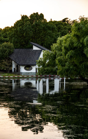 Sunset over the lake in the park with a small church in the backgroundの写真素材