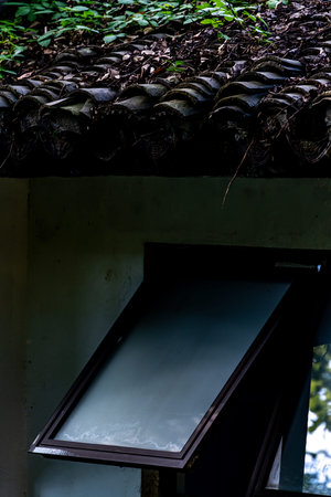 Old window on the roof of a house in the forest, Thailand.