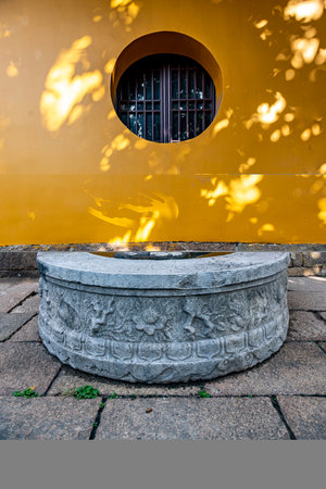 Stone fountain in front of a yellow building, chinese style.の写真素材