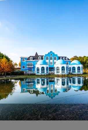 Beautiful blue house on the shore of the lake, with reflectionの写真素材