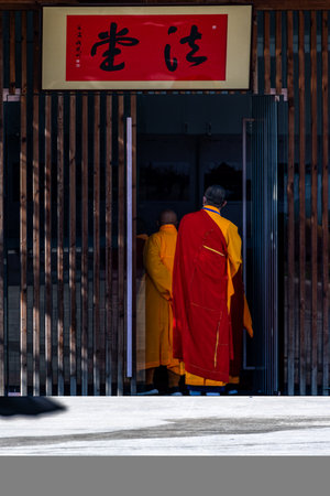 Buddhist monks walking in front of the entrance to the templeの写真素材