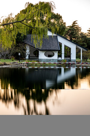Pavilion on the lake with trees reflecting in the water.の写真素材