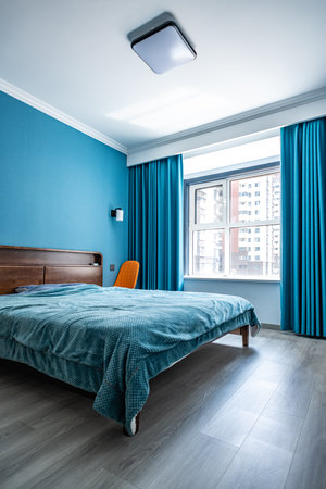 Interior of a modern bedroom with blue curtains and bed. Nobody insideの写真素材