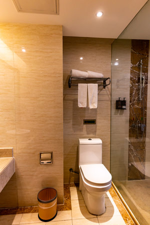 Interior of a hotel bathroom with shower, toilet and toilet bowlの写真素材