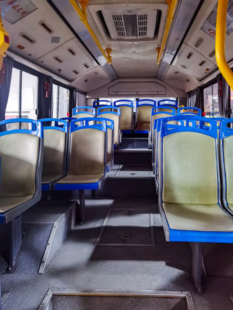 Interior of a public bus with seats and blue seats in a rowの写真素材