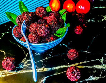 Fruits and berries in blue bowl on black marble background. Selective focus.の写真素材