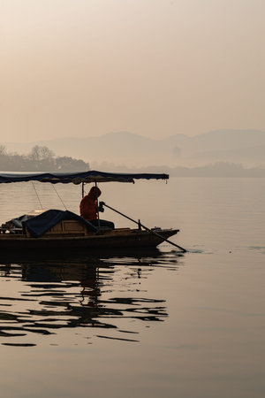 Fisherman in a boat on the lake in the morning.の写真素材
