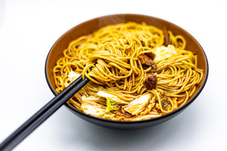 Noodles with vegetables and mushrooms in a bowl on a white backgroundの写真素材