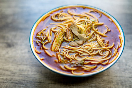 Thai spicy instant noodle soup in a bowl on wooden table