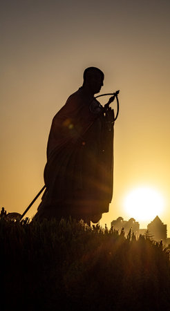 Silhouette of a buddha statue at sunset, Thailand.の写真素材