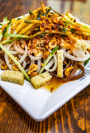 Thai spicy papaya salad in white plate on wooden table.の写真素材