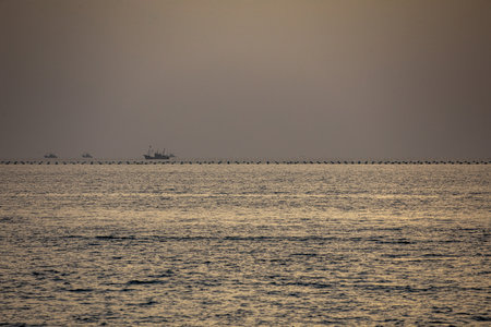 Fishing boat in the middle of the sea in the evening.の写真素材