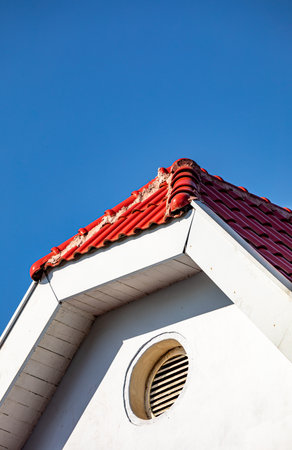 roof of the house with red tiles against the blue sky.の写真素材