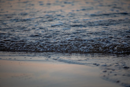 Water splashes on the beach at sunset. Shallow depth of field.の写真素材