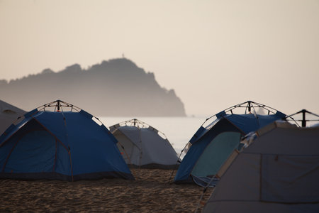Camping tents on the beach in a foggy morning at the seaの写真素材