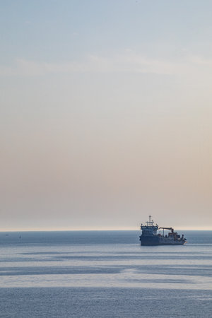 Cargo ship in the sea at sunset, closeup of photoの写真素材