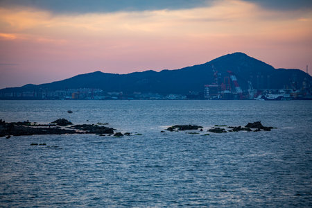 Seascape of Hong Kong at sunset with mountains in the backgroundの写真素材