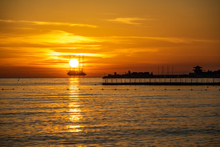 Beautiful sunset in the sea with silhouette of a ship on the horizonの写真素材