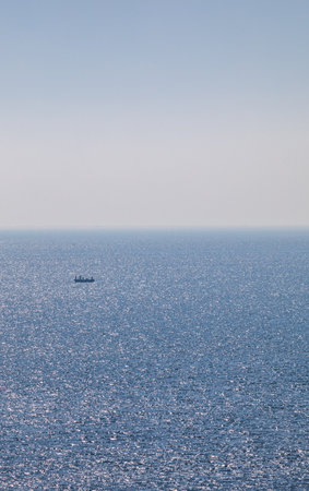 Fishing boat in the open sea on a background of blue skyの写真素材