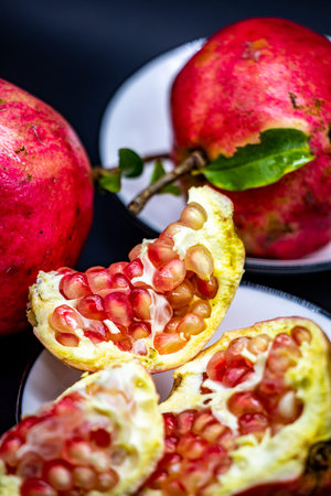 Pomegranate fruits on a black background. Selective focus.