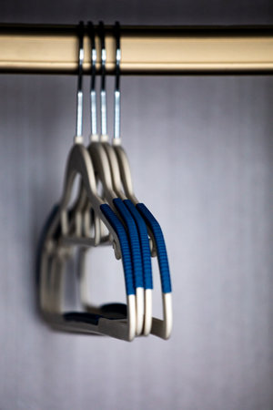Clothes hanger with blue handles on a gray wall background.の写真素材