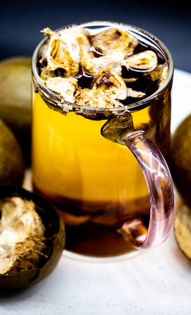 Mulled wine with walnuts on a white wooden table.