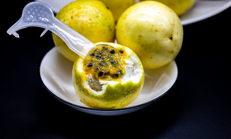 Passion fruit in a white bowl on black background, healthy food concept